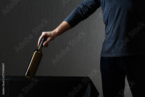 Quadro su tela Man picks up a bottle of white wine.
