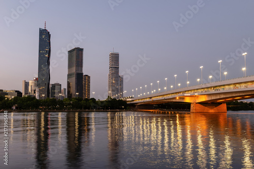 Vienna Donau City skyline with DC Tower and Reichsbruecke bridge reflected in the Danube River at twilight, Austria