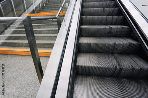 Quadro su tela Modern escalator and adjacent staircase inside public transport terminal