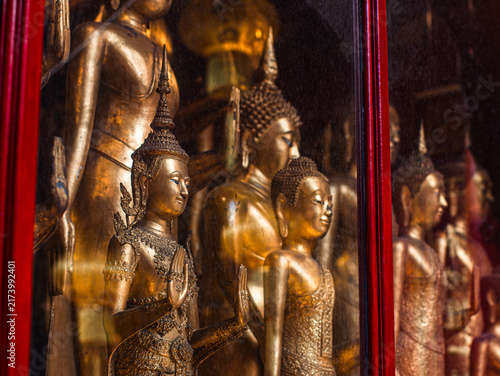 Obraz na płótnie Golden Buddha Statues Reflected in Glass Cabinet, Sacred Thai Temple Collection