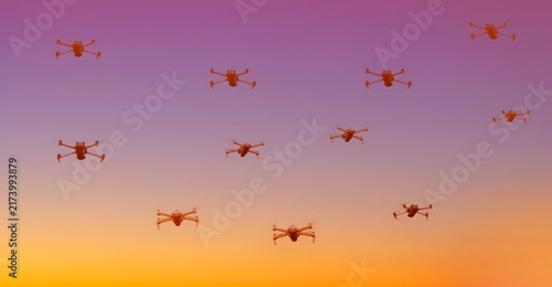 Group of surveillance drones in front with sunset sky scene background