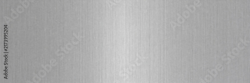 Brushed metal texture background, silver stainless steel surface with vertical grain, industrial aluminum plate with metallic sheen, sleek grey chrome backdrop for tech product design