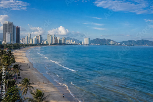 High rise Vietnamese resort city stretching along a long sandy beach and calm blue bay.generative AI