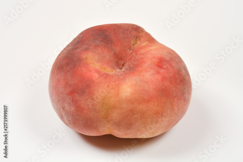 Fotografía A whole ripe flat peach also known as saturn peach isolated on a clean white sur