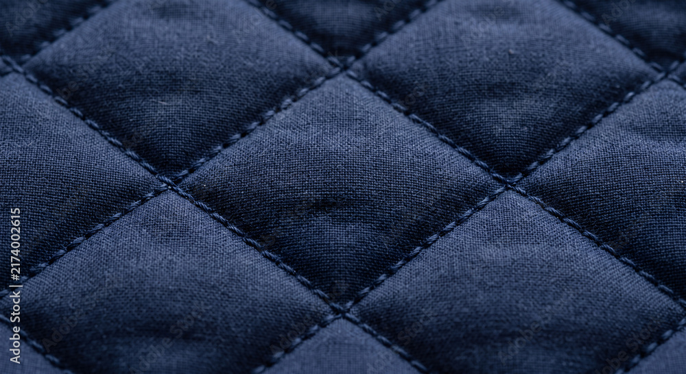 Obraz premium Close up of navy blue quilted fabric with diamond stitching pattern