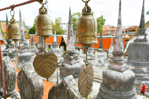 Foto Close-up of traditional temple bells with blurred small stupas in background at