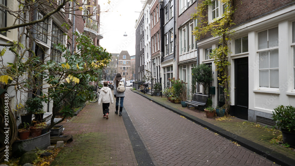 Obraz premium Mother and son walking on amsterdam street