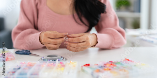 Canvastavla Close up hands of woman Woman at home spends time on hobby Stringing beads