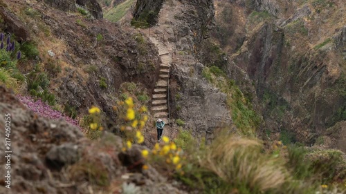 Madeira, Portugal - July 13, 2026: Hiker walking along the narrow stone staircase on the rugged mountain trail between Pico do Arieiro and Pico Ruivo. 4K video.