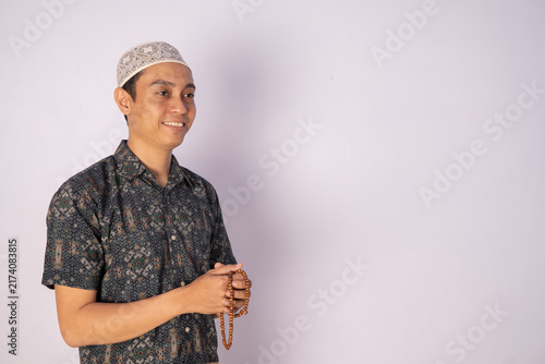 Prayerful Man Holding Prayer Beads with Warm Smile Portraying Peace and Spirituality