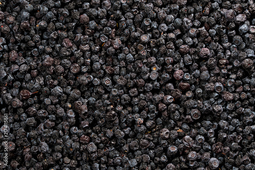Full frame texture of dried organic blueberries background. Top view closeup of large pile of dark dried blueberries creating detailed natural berry texture pattern