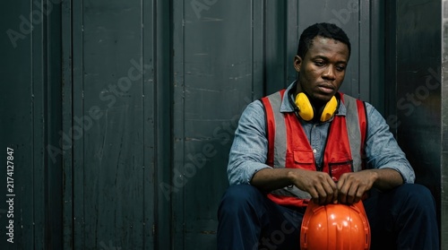 Construction worker burnout, job stress, safety pressure concept with tired worker holding helmet.