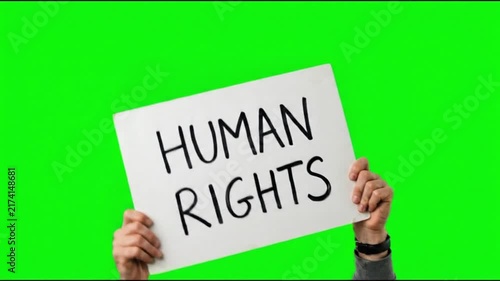 Hands holding a banner sign with the text human rights on a green screen chroma key background