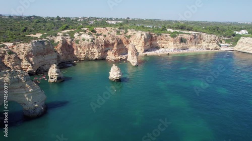 Stunning aerial footage of the Praia da Marinha in the Algarve region, Portugal. The video showcases the beautiful cliffs and crystal clear water
