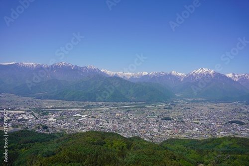 Fotografía 北アルプス　鷹狩山から望む残雪の北アルプスと新緑の大町市街