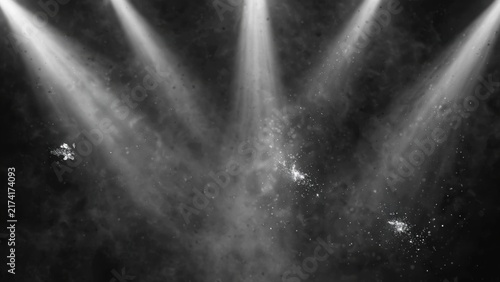 Three bright spotlights illuminate a hazy, smoky stage with scattered sparks