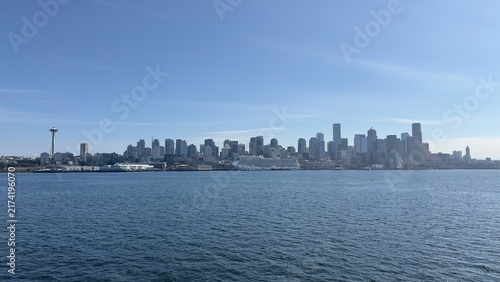 Photography Seattle’s waterfront in daylight, with Elliott Bay, bustling piers, and the city skyline stretching along the shore
