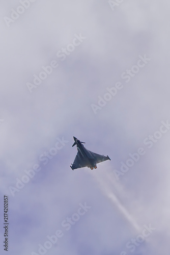 Eurofighter Typhoon jet fighter plane doing a steep climb on a cloudy day with afterburners engaged