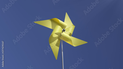 Yellow pinwheel spinning on a white stick against a solid blue sky, with curved blades and metal axle.
