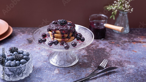 Konstfotografi Berry Pancakes on Glass Cake StandHomemade pancakes topped with berry compote fr