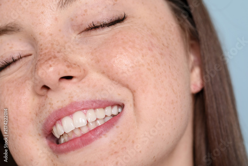 Foto Beautiful teenage girl with freckles on light blue background, closeup