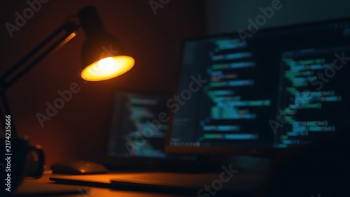 Nighttime workspace with warm lamp glow and abstract coding concept in minimalist style.