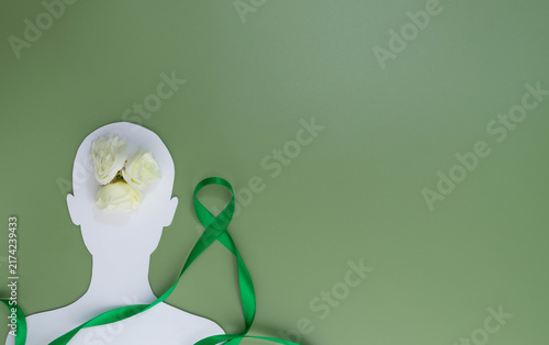 Human silhouette with flowers and green ribbon symbolizing mental health