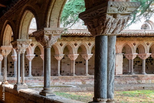 фотографія Carved stone capitals and double columns frame an ancient monastic cloister