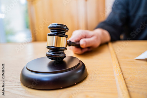 Macro Close-up of Judge's Gavel and Sound Block on Courtroom Table