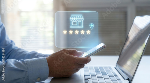 Hand holding smartphone showing five star shop rating online