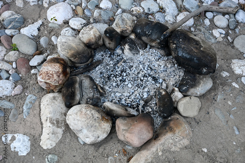 Canvastavla Cold gray wood ash and charcoal in a makeshift rock campfire ring