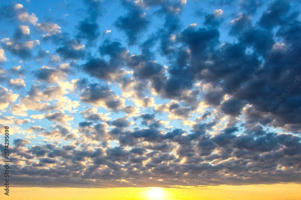 Fototapeta premium Colorful clouds in the sky at sunset over a wide landscape with changing light