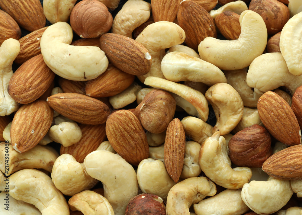 Obraz premium Detailed view on almond and cashew nuts in big pile on table close up