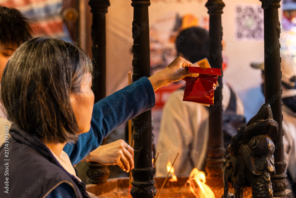Obraz premium Worshipper Purifies Red Packet Over Temple Flame