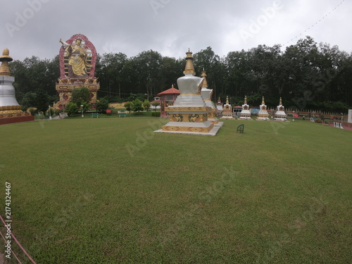 Принти на полотні A peaceful outdoor view of a Buddhist monument or Buddha statue situated in a landscaped garden