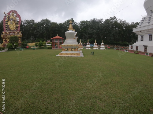 Принти на полотні A peaceful outdoor view of a Buddhist monument or Buddha statue situated in a landscaped garden