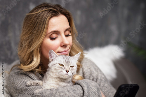 Canvastavla housewife and gray cat together at home