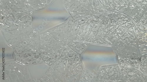 Obraz na plátně Close-up of translucent textured privacy window film with an irregular decorative glass pattern and subtle rainbow reflections, creating an abstract bright background