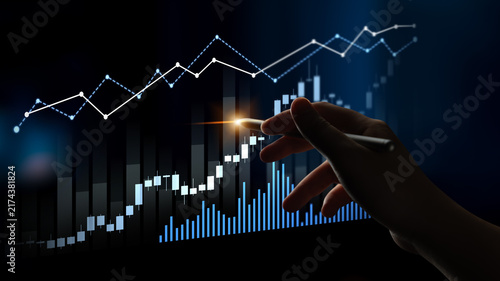 Foto A hand holding a stylus points at a financial chart with rising graph lines, representing growth and analysis in a dark background, ideal for business concepts