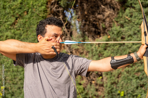 Archer holding a bow and arrow, focusing on hitting the target