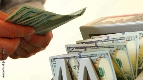 US dollar. Business and economic concept. A money counter with US dollars and a businessman counting money. Financial background. Close up
