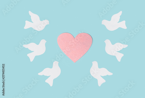 Фотография International Day of Peace concept with white peace doves and pink heart symboli