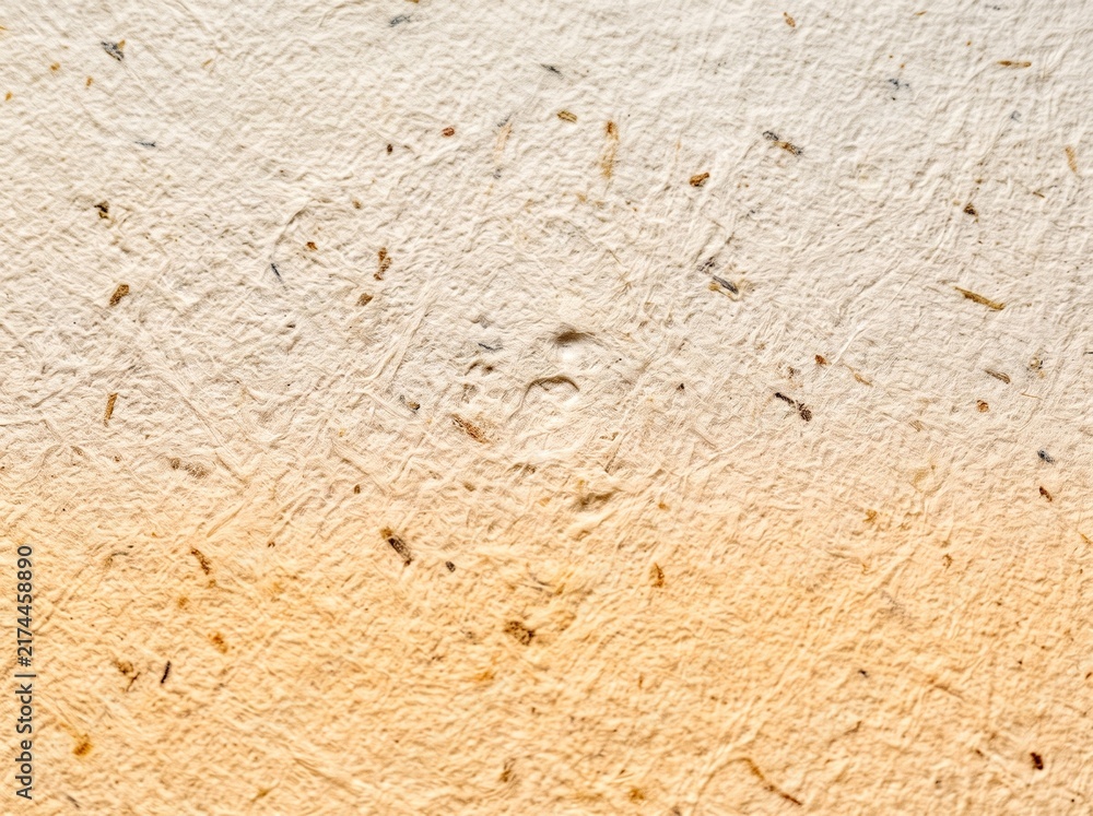 Fototapeta premium Recycled beige handmade paper texture featuring organic fiber flecks and subtle warm gradient lighting closeup detail