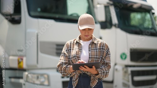 Female truck driver using a tablet for logistics management