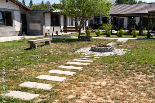 Modern Resort Courtyard with Stone Pathway and Outdoor Fire Pit.