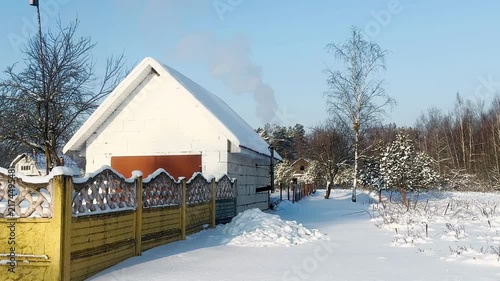 Smoke from a stove pipe. Winter rural landscape.
