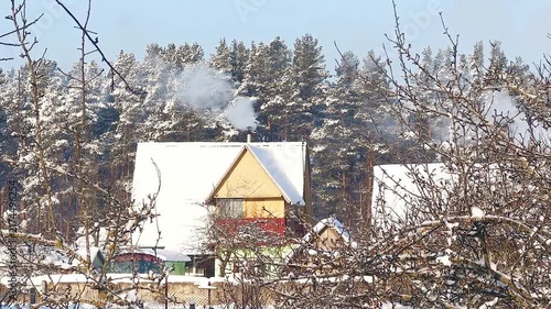 Smoke from a stove pipe. Winter rural landscape.
