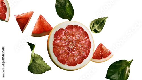 Quadro su tela Isolated vibrant red grapefruit slices and half fruit with green leaves, fresh and juicy citrus