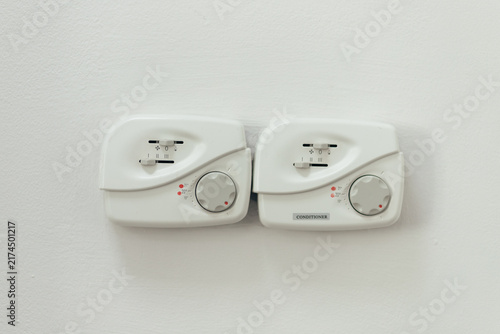 Pair Of White Climate Control Panels Mounted On Wall. Dual Zone Thermostats Display Temperature Settings And Indicator Lights.