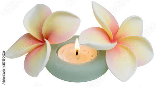 Foto Isolated tropical frangipani flowers and a lit tealight candle in a serene setting